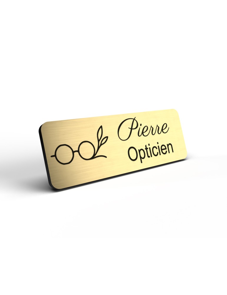 Badge personnalisé opticien, motif optique et lunetterie, détail de la finition or brossé
