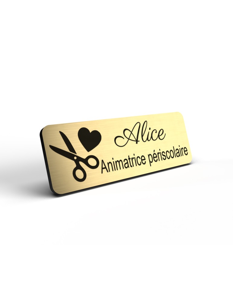 Badge personnalisé animatrice périscolaire, motif animation et activités pour enfants, détail de la finition or brossé