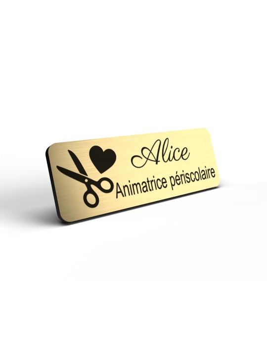 Badge personnalisé animatrice périscolaire, motif animation et activités pour enfants, détail de la finition or brossé