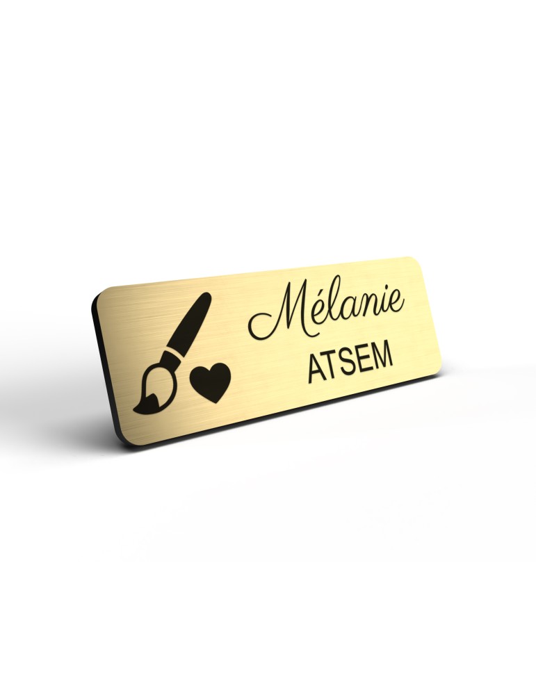 Badge personnalisé atsem, motif école maternelle et petite enfance, détail de la finition or brossé