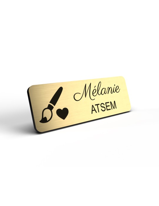 Badge personnalisé atsem, motif école maternelle et petite enfance, détail de la finition or brossé