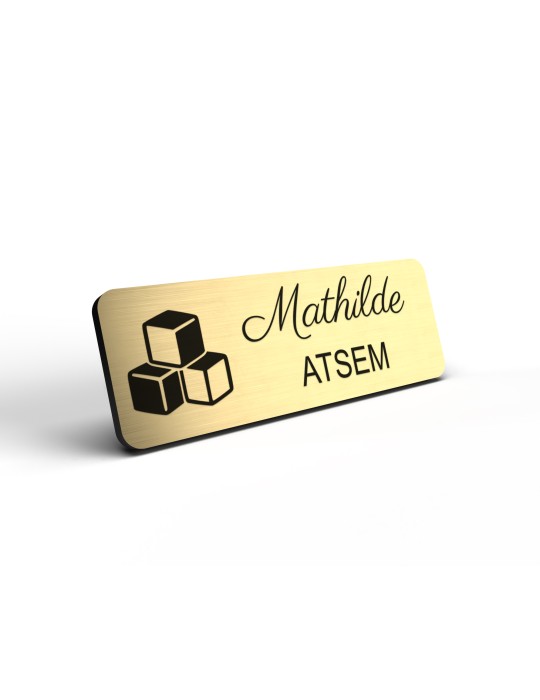 Badge personnalisé atsem, motif école maternelle et petite enfance, détail de la finition or brossé