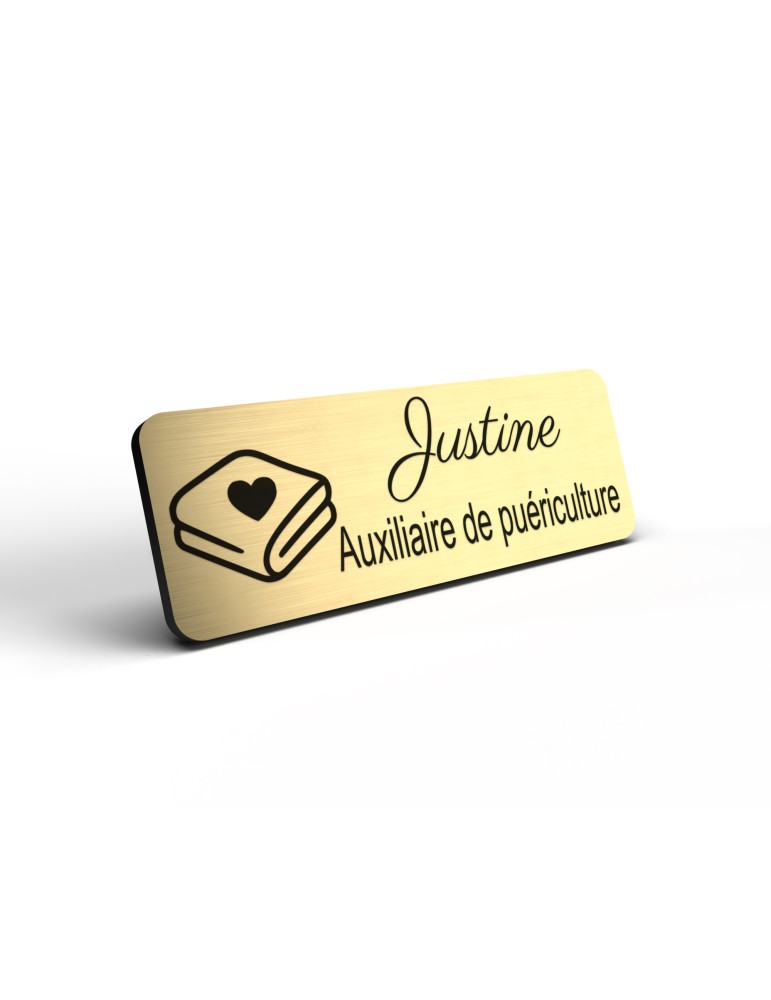 Badge personnalisé auxiliaire de puériculture, motif bébé et soins de puériculture, détail de la finition or brossé