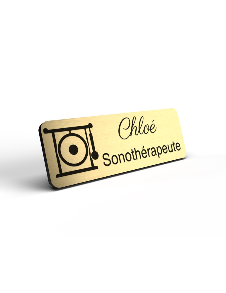 Badge personnalisé sonothérapeute, motif sonothérapie et vibrations sonores, détail de la finition or brossé