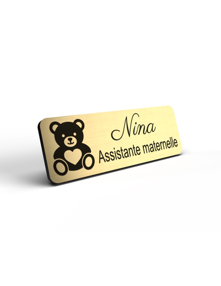 Badge personnalisé assistante maternelle, motif accueil familial et petite enfance, détail de la finition or brossé