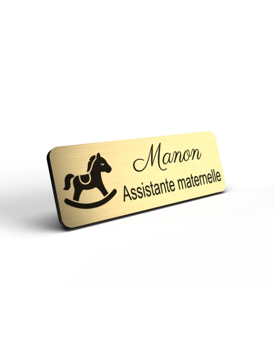 Badge personnalisé assistante maternelle, motif accueil familial et petite enfance, détail de la finition or brossé