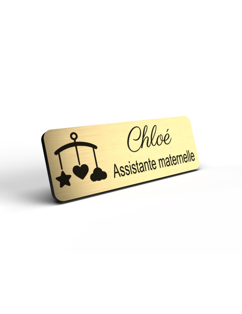 Badge personnalisé assistante maternelle, motif accueil familial et petite enfance, détail de la finition or brossé