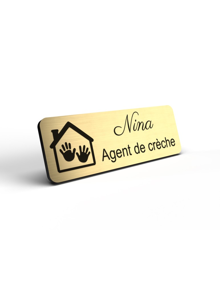 Badge personnalisé agent de crèche, motif crèche et accueil des jeunes enfants, détail de la finition or brossé